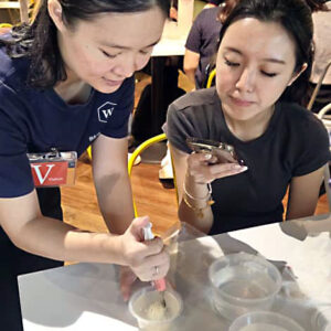 Image of our collaborator Winnie of W Baking Studio giving a demo of the jelly cake making process to one of the PwC participants